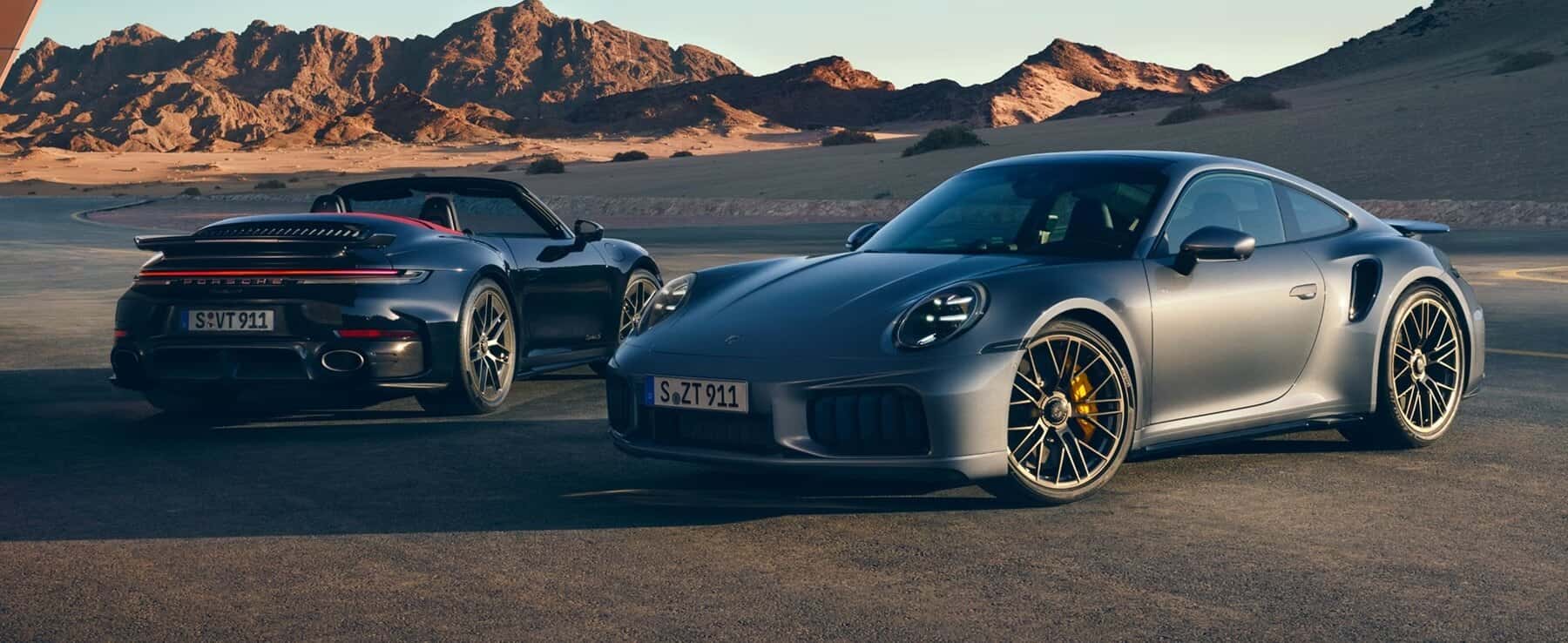 Two Porsche 911 Turbo S models parked outside