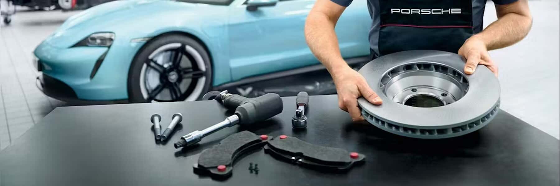 Porsche technician holding Porsche parts