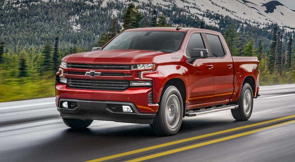 A red 2021 Chevy Silverado is shown driving down the highway after leaving a Louisville Chevy dealer.