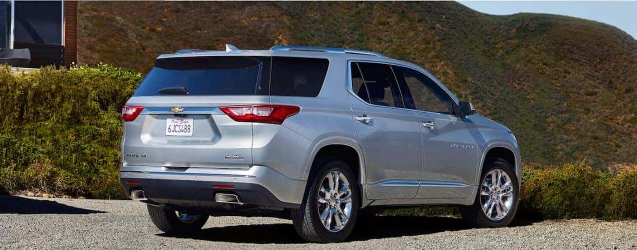 A silver 2021 Chevy Traverse is shown from behind overlooking mountains.