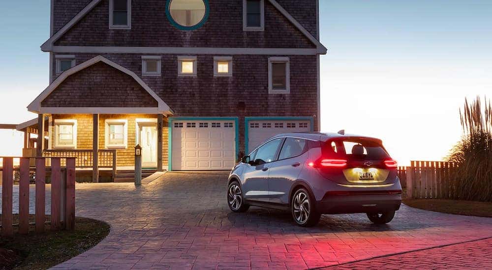 A silver 2022 Chevy Bolt EV is shown from behind with its tail lights illuminated.