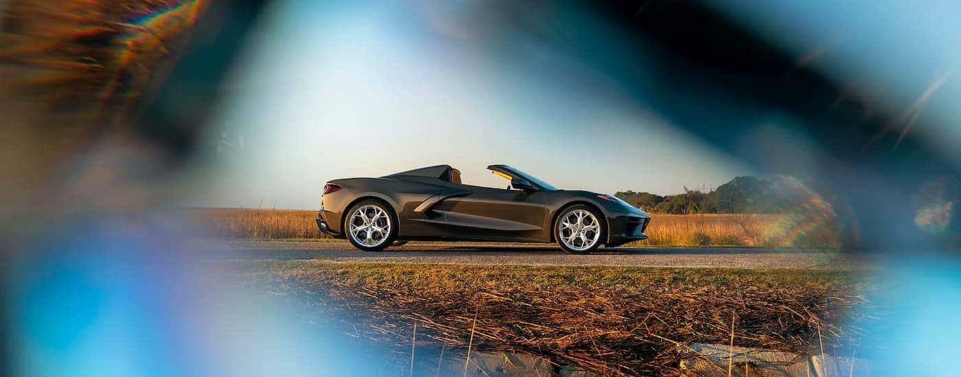 A brown 2020 Chevy Corvette is shown from the side parked next to a field.