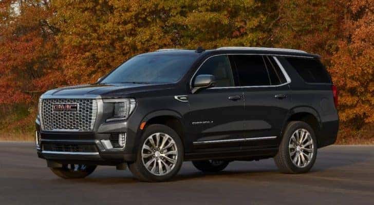 A black 2021 GMC Yukon Denali is parked in front of fall trees after leaving an Indiana GMC Dealership.