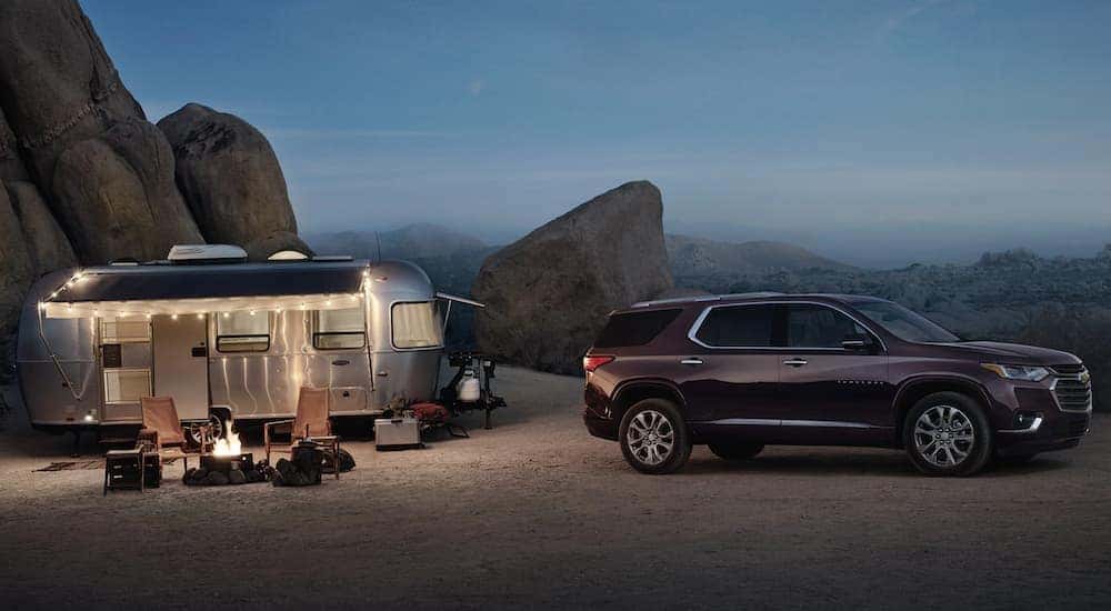 A burgundy 2020 Chevy Traverse is at a campsite with an Airstream trailer.