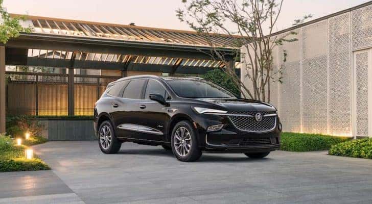 A black 2022 Buick Enclave i shown parked in a modern driveway.