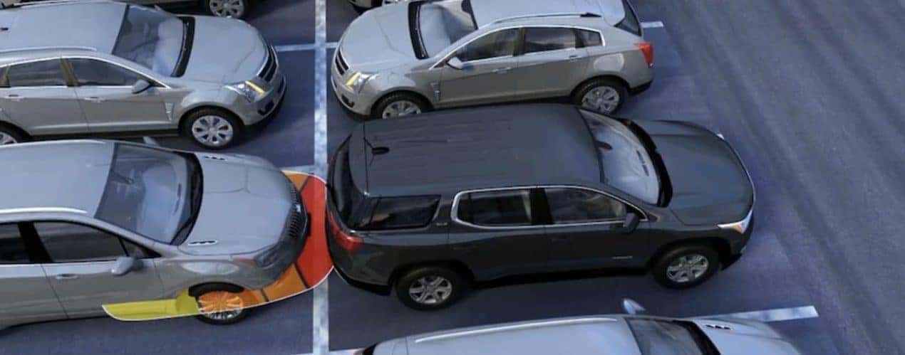 A 2022 GMC Acadia is shown backing into a parking space.