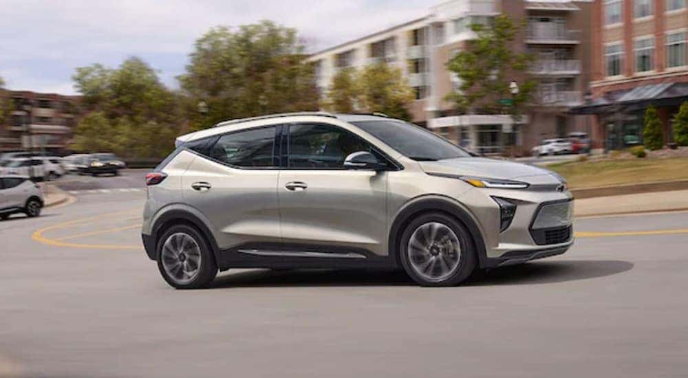 A silver 2022 Chevy Bolt EUV is shown from the side driving through the city after leaving a Chevy EV dealer.