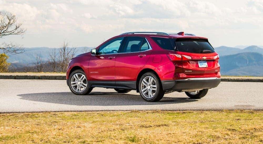 A red 2020 Chevy Equinox is shown parked in a lot in front of mountains.