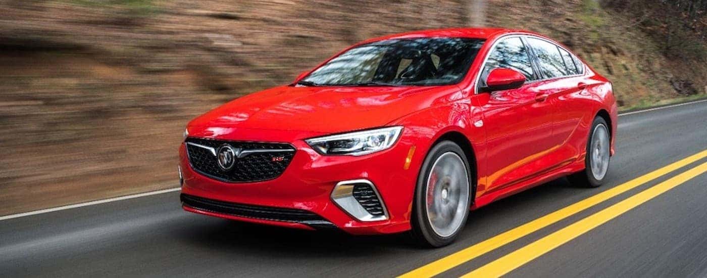 A red 2019 Buick Regal GS is shown from the side driving on a two lane road.