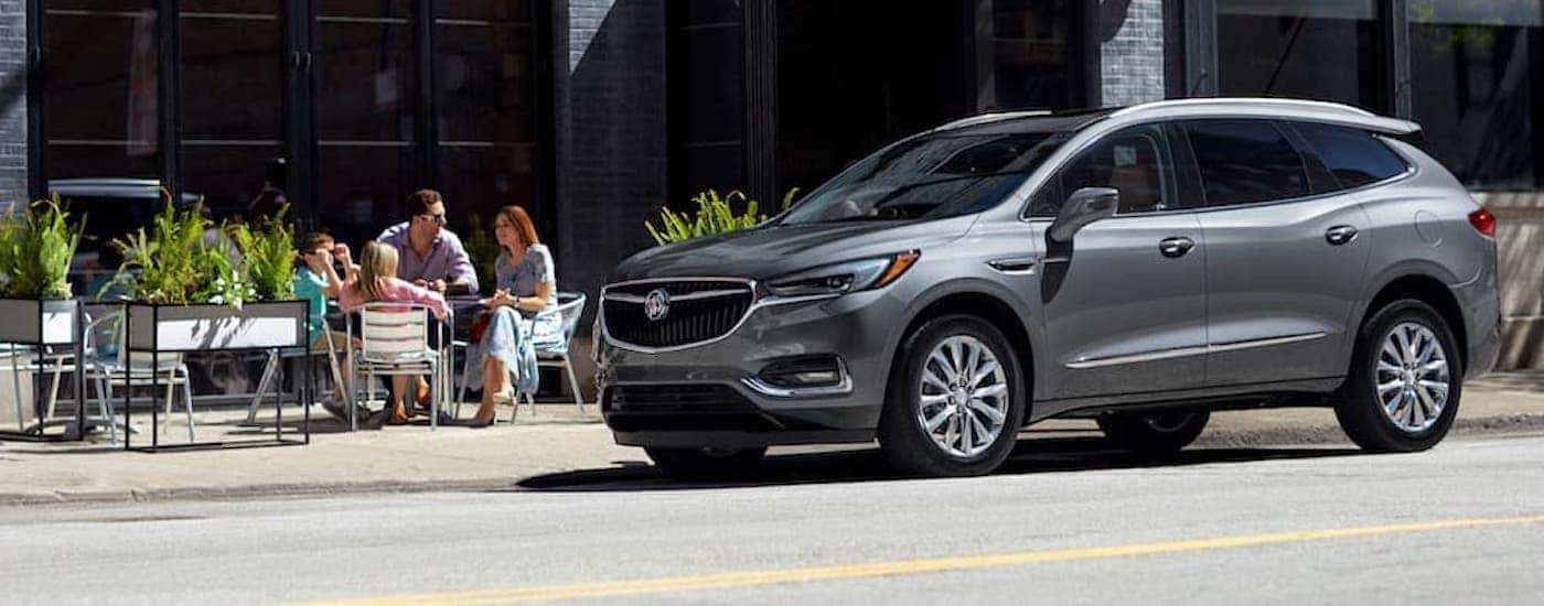 A silver 2020 Buick Envision is shown from the side parked on a city street.