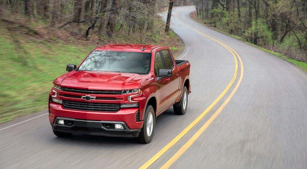 A red 2019 Chevy Silverado 1500 RST is shown driving on a winding road.