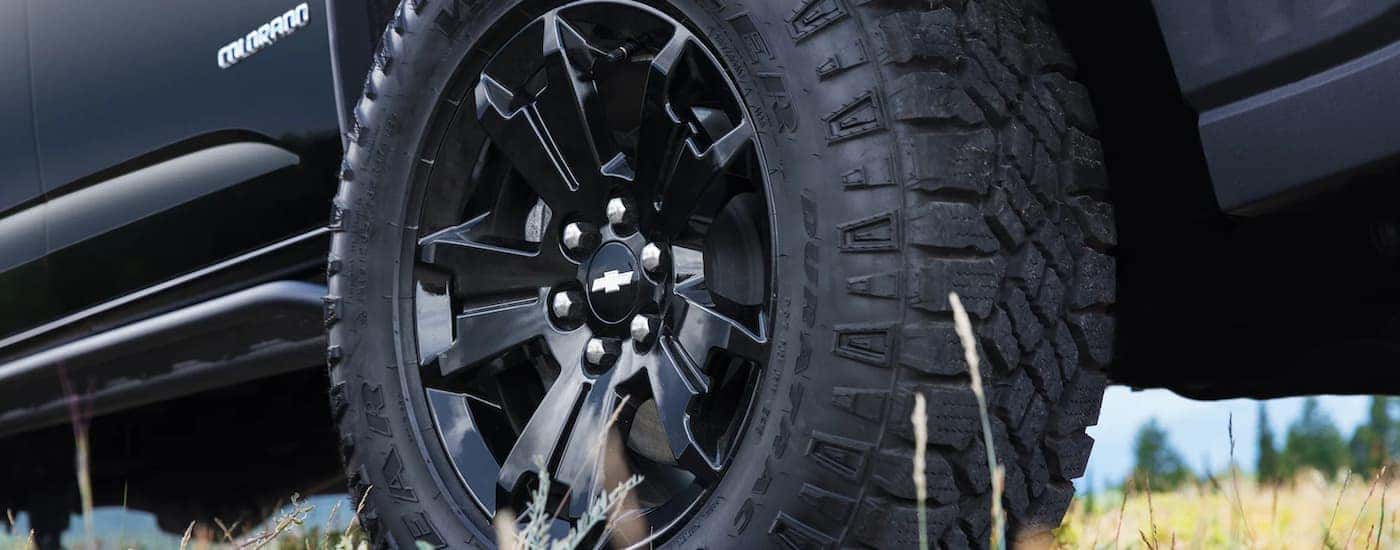 A close up shows the black wheel on a black 2022 Chevy Colorado.