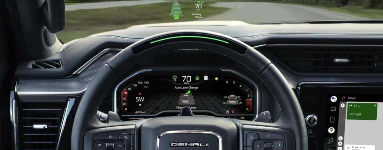The black interior of a 2022 GMC Sierra 1500 shows the steering wheel and dashboard.