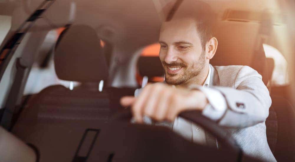 A man is shown in a vehicle after researching 'how to sell your car.'