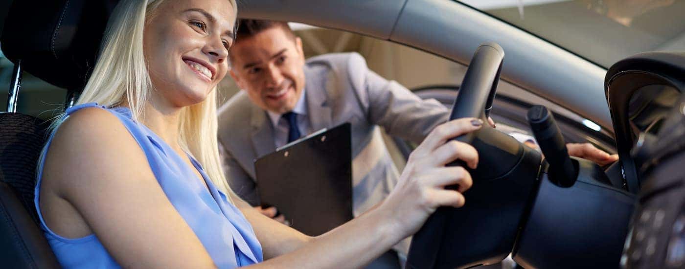 A salesperson and a woman are shown before a test drive at a Louisville used car dealership.