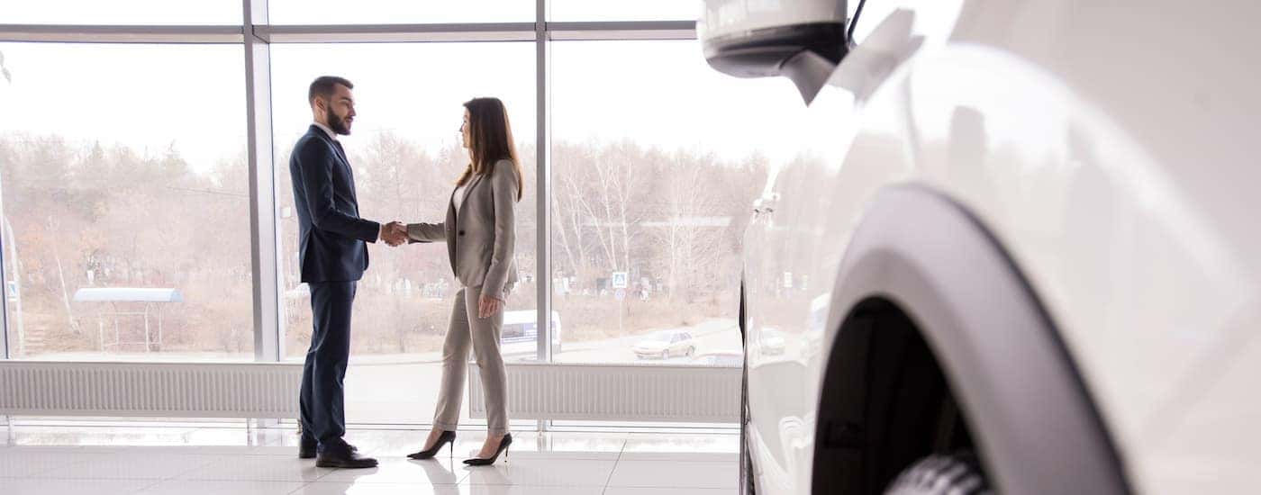A salesperson is shown shaking hands at a Chevy dealer in Louisville.