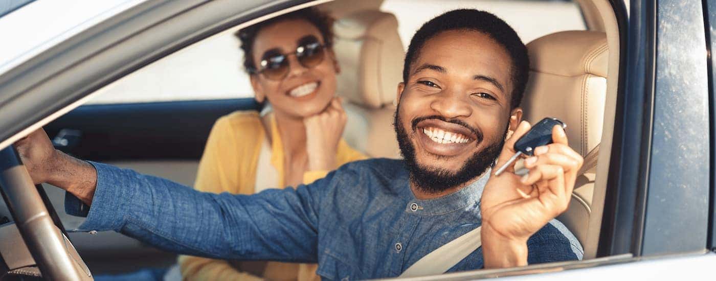 A couple is shown sitting in the front seat of a car at a Chevy dealer in Louisville.