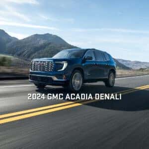 2024 GMC Acadia Denali Driving with Mountains in the Background