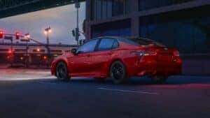 red toyota camry driving on the street