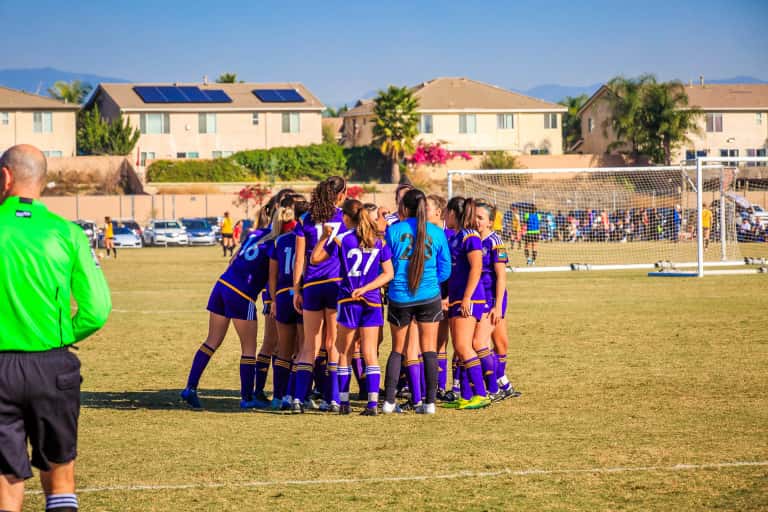 A huddle of girls on the soccer field