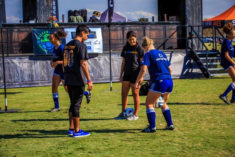 two girls and a boy passing the soccer ball to each other