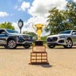 two mercedes-benz vehicles parked infront of golf trophy