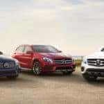 Three Mercedes-Benz cars parked in a row out in the desert