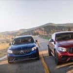 Two Mercedes-Benz SUVs racing side-by-side on a desert highway