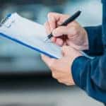 Mechanic writing on a clipboard