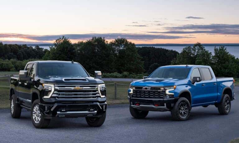 Two 2024 Chevy Silverado 2500 HD's parked by lake