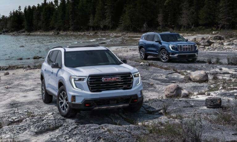 2024 GMC Acadia exterior two side by side on rocky beach