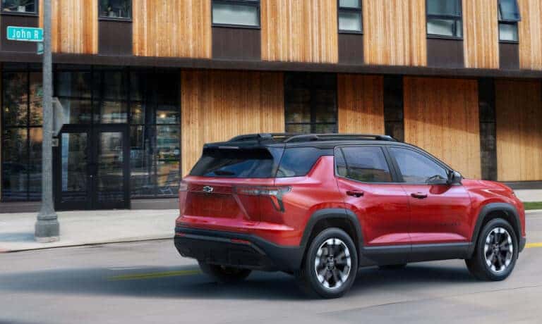 2027 Chevy Equinox driving past wooden building