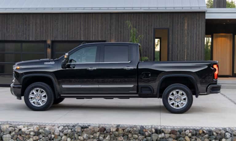 2026 Chevy Silverado 2500 HD side view by modern house