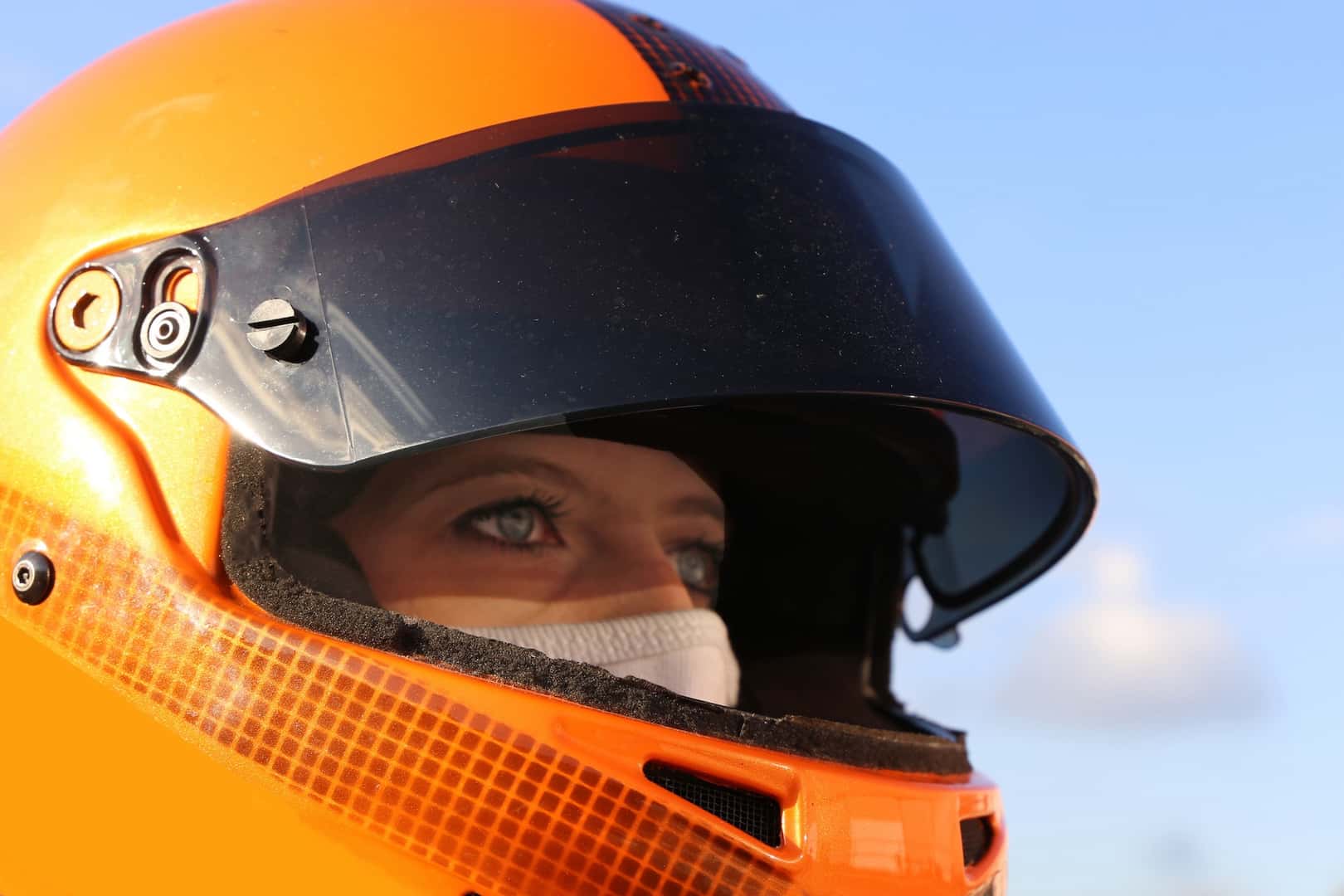 Female race car driver wears helmet and balaclavad