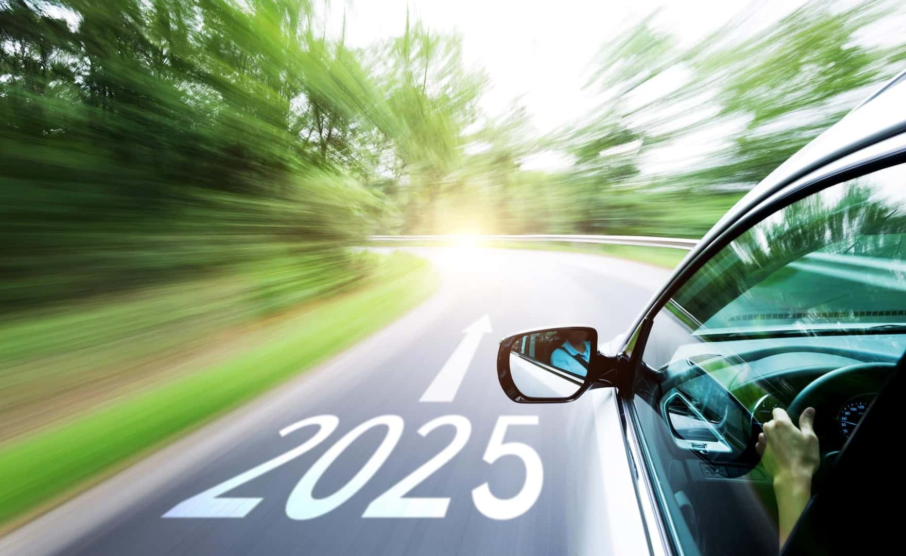 Man hand driving car through the forest, with number 2025 and arrow sign on the road