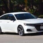 A portrait of a white Honda Accord Hybrid cruising near Hermann Park in Houston.