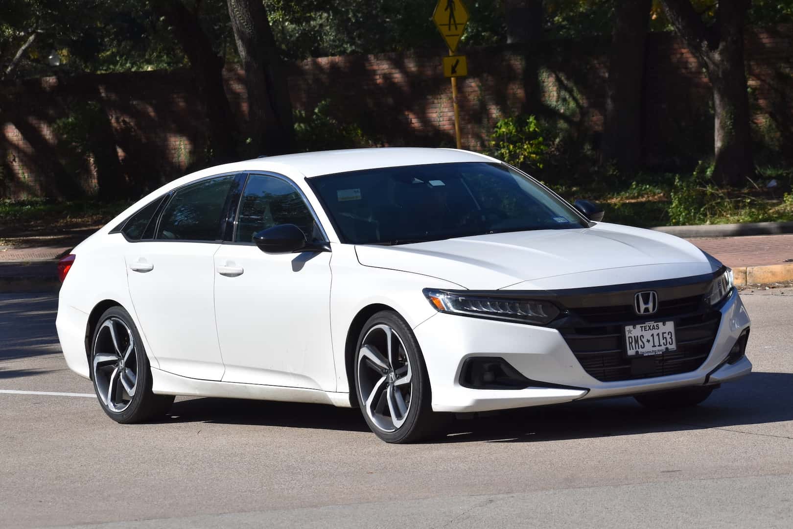 A portrait of a white Honda Accord Hybrid cruising near Hermann Park in Houston.