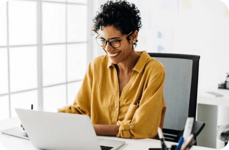 Lady sitting at her desk working on her laptop