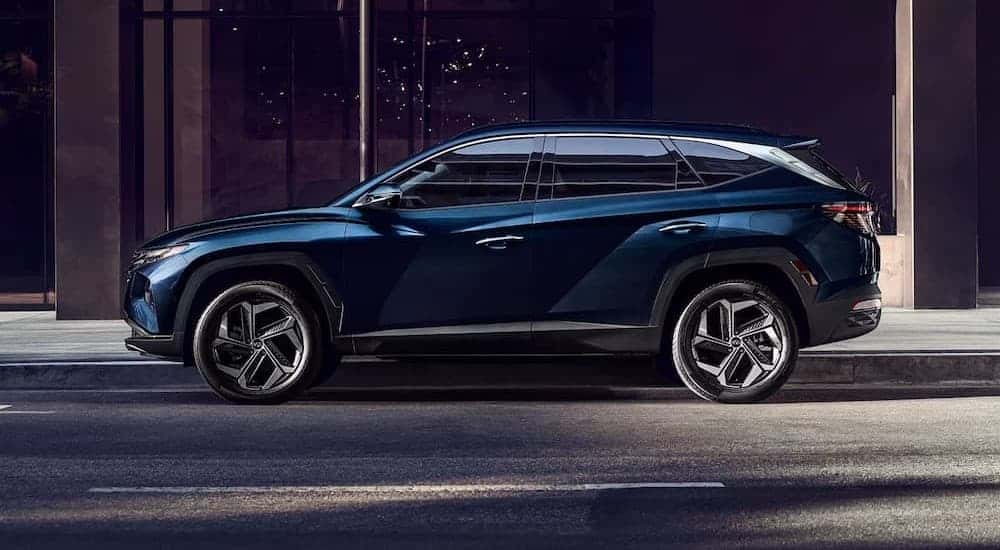 A blue 2023 Hyundai Tucson parked in a city.