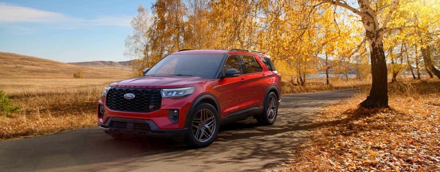 Red 2026 Ford Explorer ST parked on a tree lined autumn road
