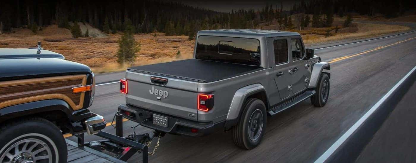 A gray 2022 Jeep Gladiator towing a trailer on a highway