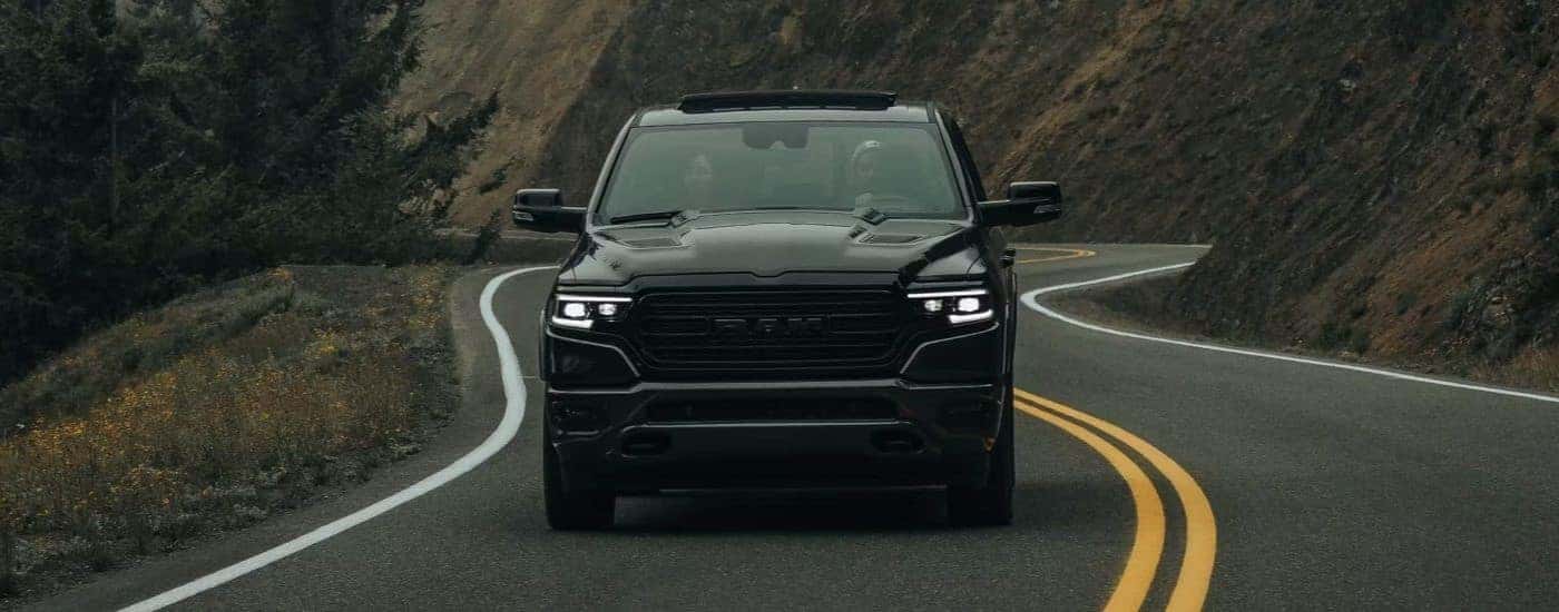 A black 2023 Ram 1500 driving on a highway