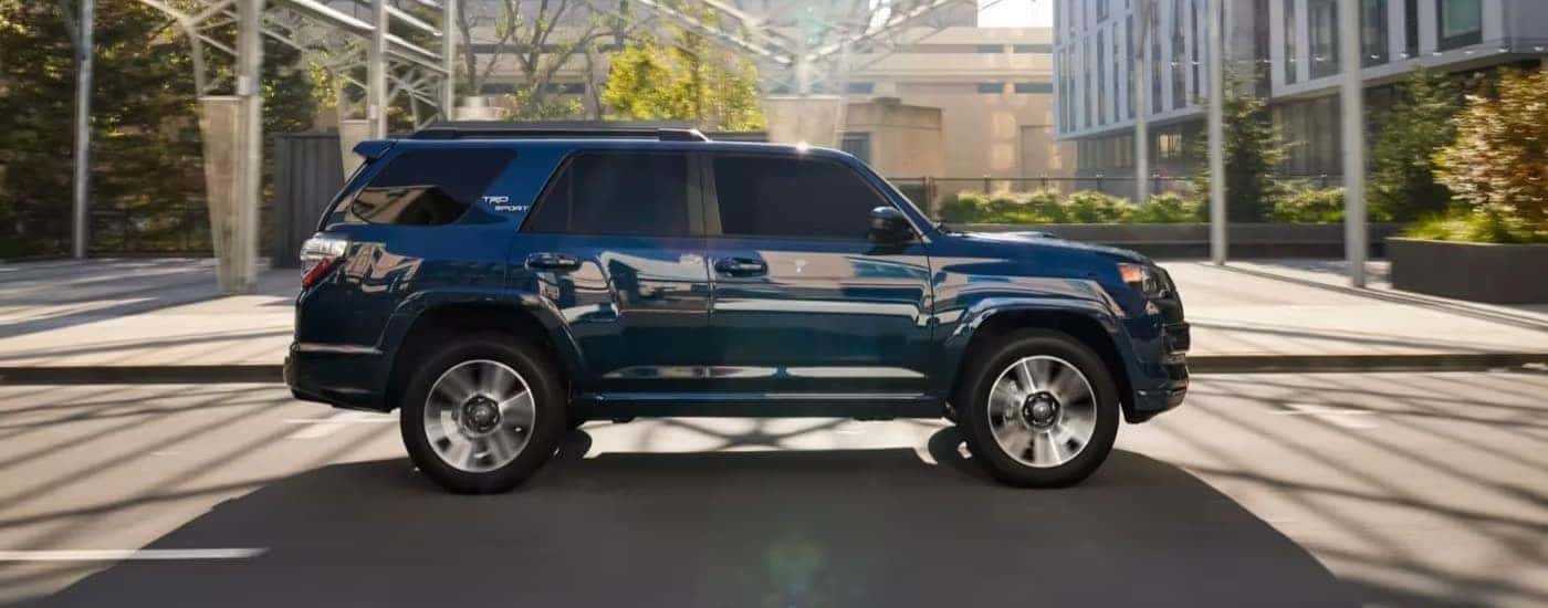 A blue 2023 Toyota 4Runner Sport from a side angle driving down a city street