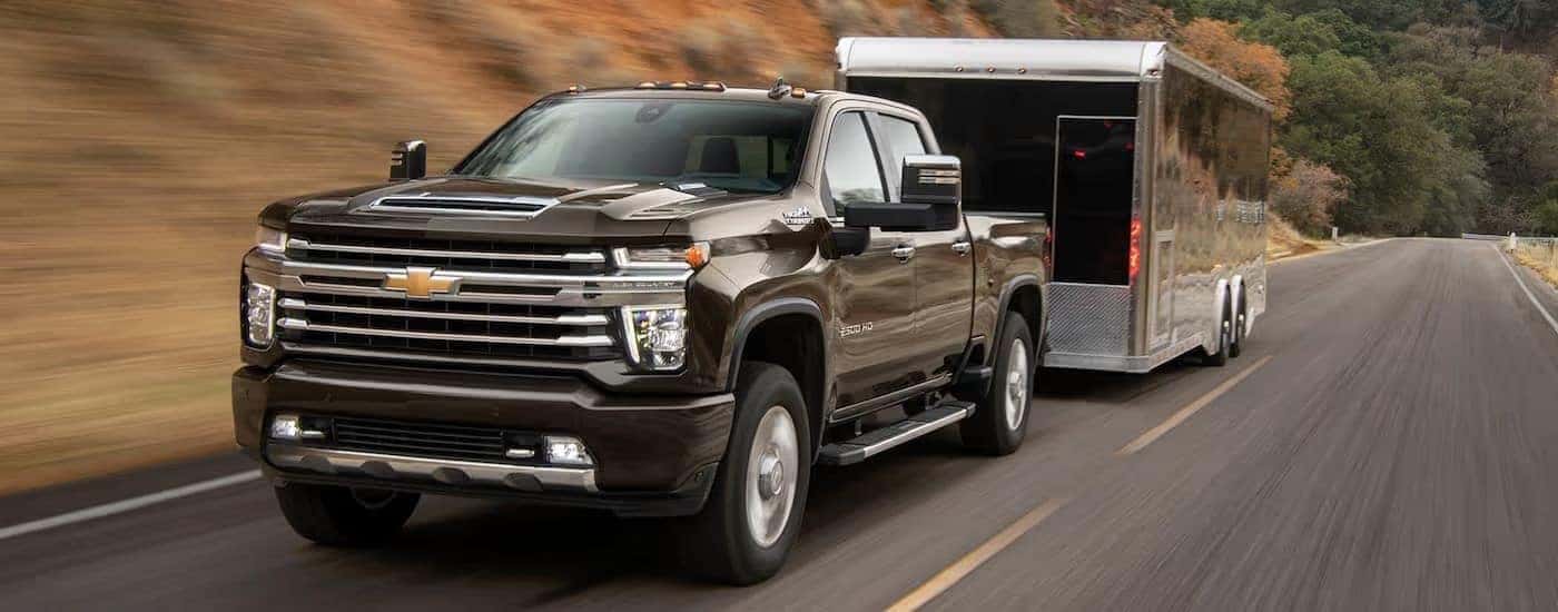 A black 2021 Chevy Silverado 2500 HD High Country towing a trailer.