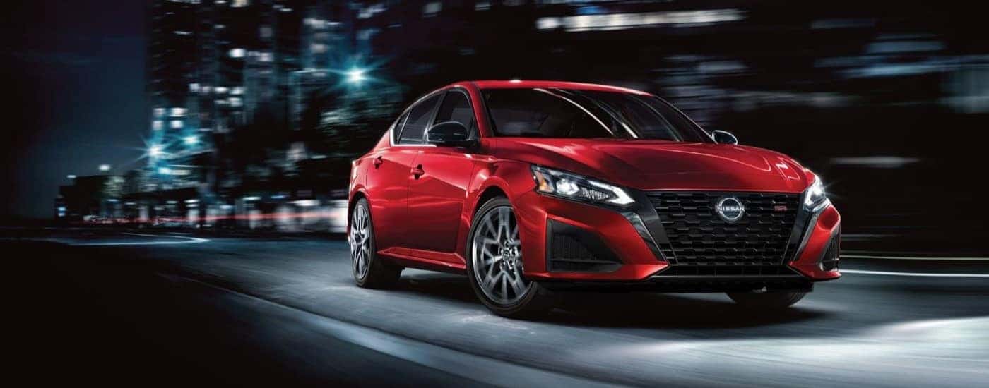 A red 2023 Nissan Altima shown on a city highway.