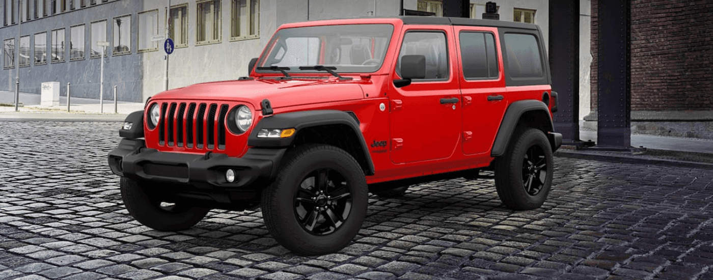 Red 2021 Jeep Wrangler parked at an angle on cobblestone