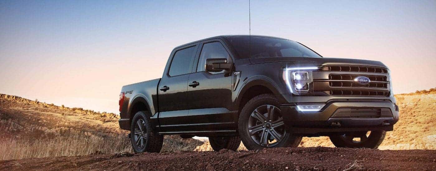 A black 2022 Ford F-150 XL Sport parked on a dirt field.