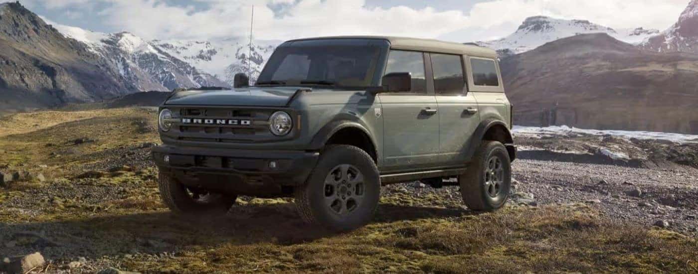 A gray 2023 Ford Bronco Big Bend parked off-road in the mountains.