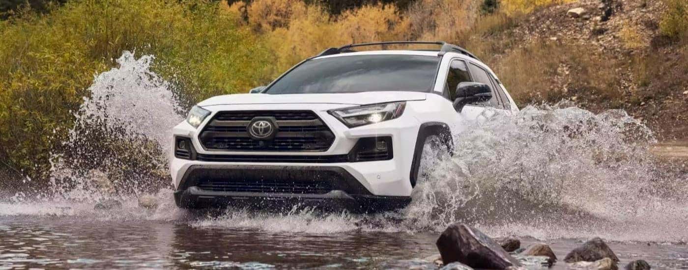 White 2023 Toyota RAV4 TRD driving through water.
