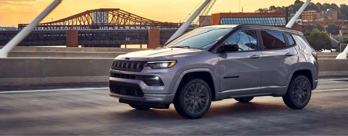 A silver 2022 Jeep Compass crossing a bridge.